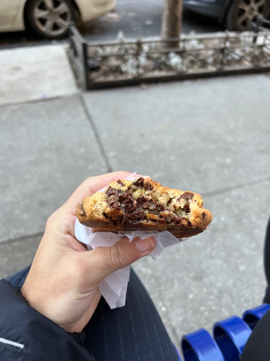 Mão segurando um cookie recheado da Portuga partido ao meio